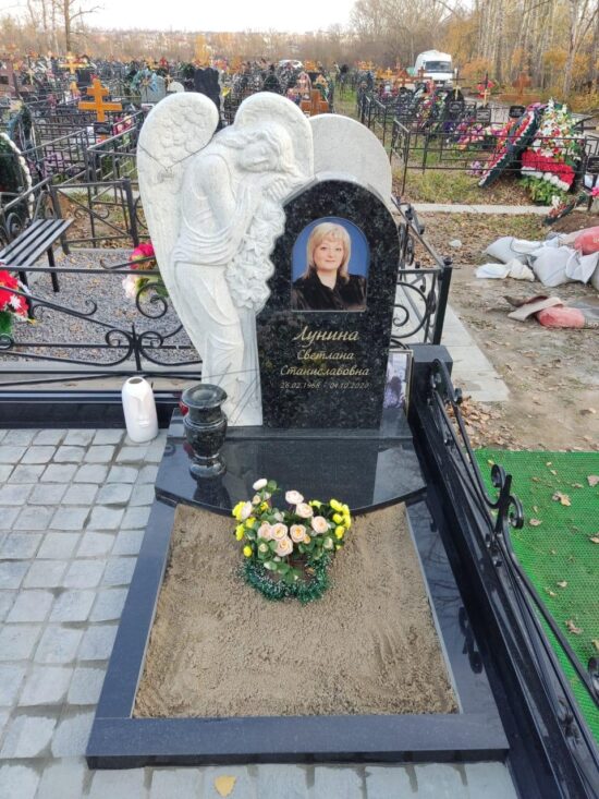 Элитный памятник со скульптурой ангела сбоку из гранита балтик грин на могилу