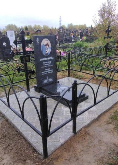Памятник из черного гранита и ограда из металла на могилу